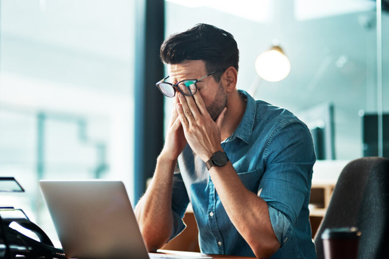 Headache, stress and tired business man at laptop in office for anxiety, debt crisis and eye strain problem. Burnout, fatigue and worker at computer with pain, brain fog and frustrated with mistake.